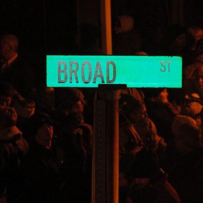A sign for Broad Street in front of people