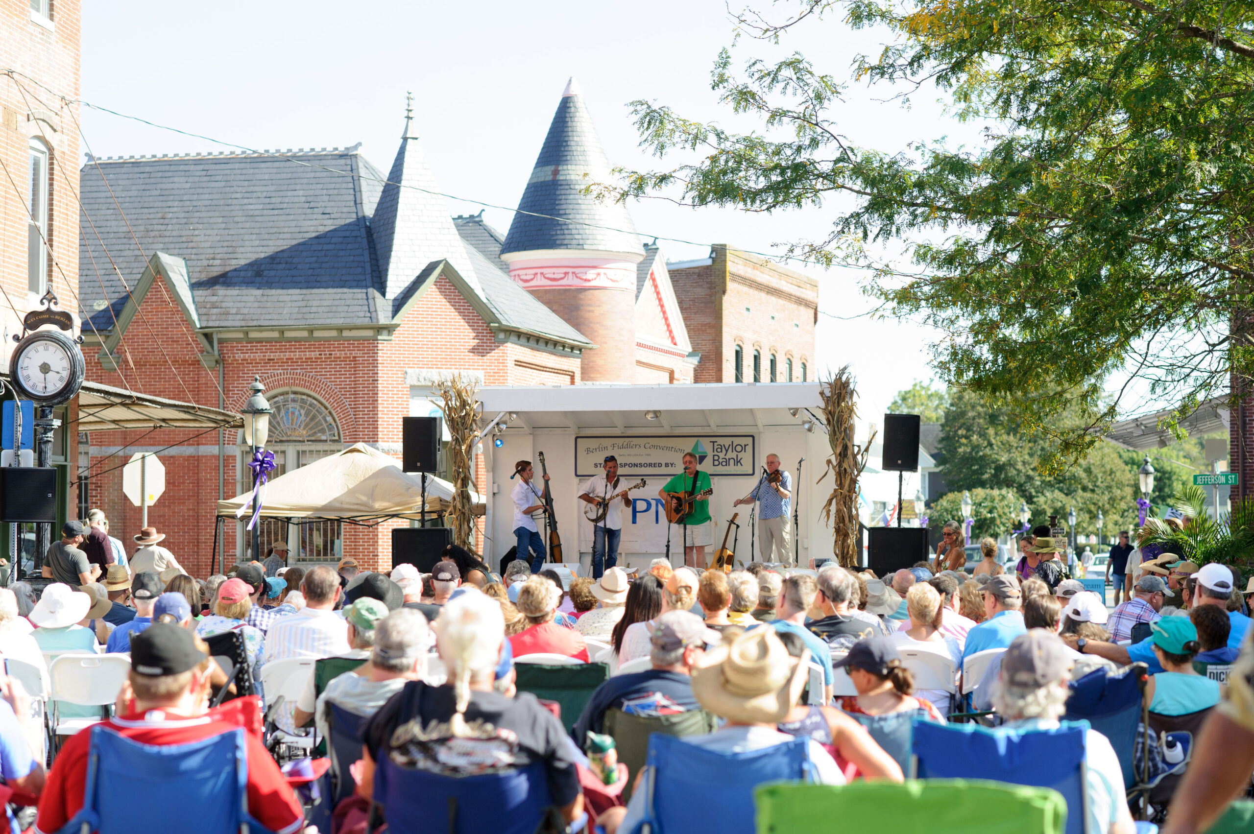 a crowd of people sitting in lawn chairs in front of a building