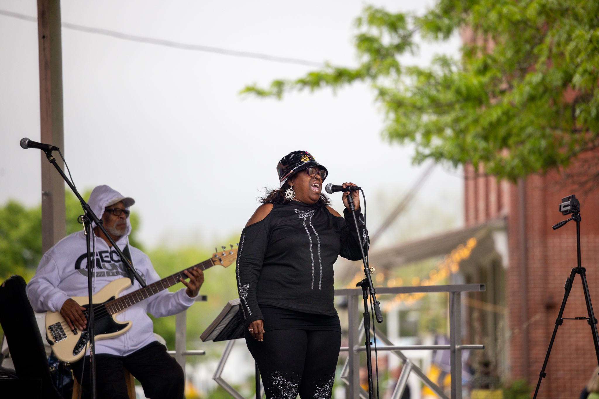 a woman singing into a microphone while playing guitar