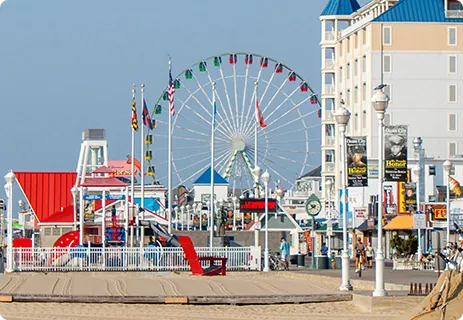 a ferris wheel on the beach next to a boardwalk