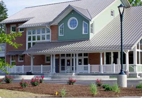 a large green house with a white porch